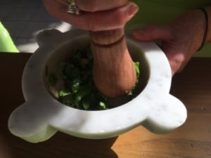 Making Pesto with a mortar and pestle, photo courtesy of Victoria DeMaio