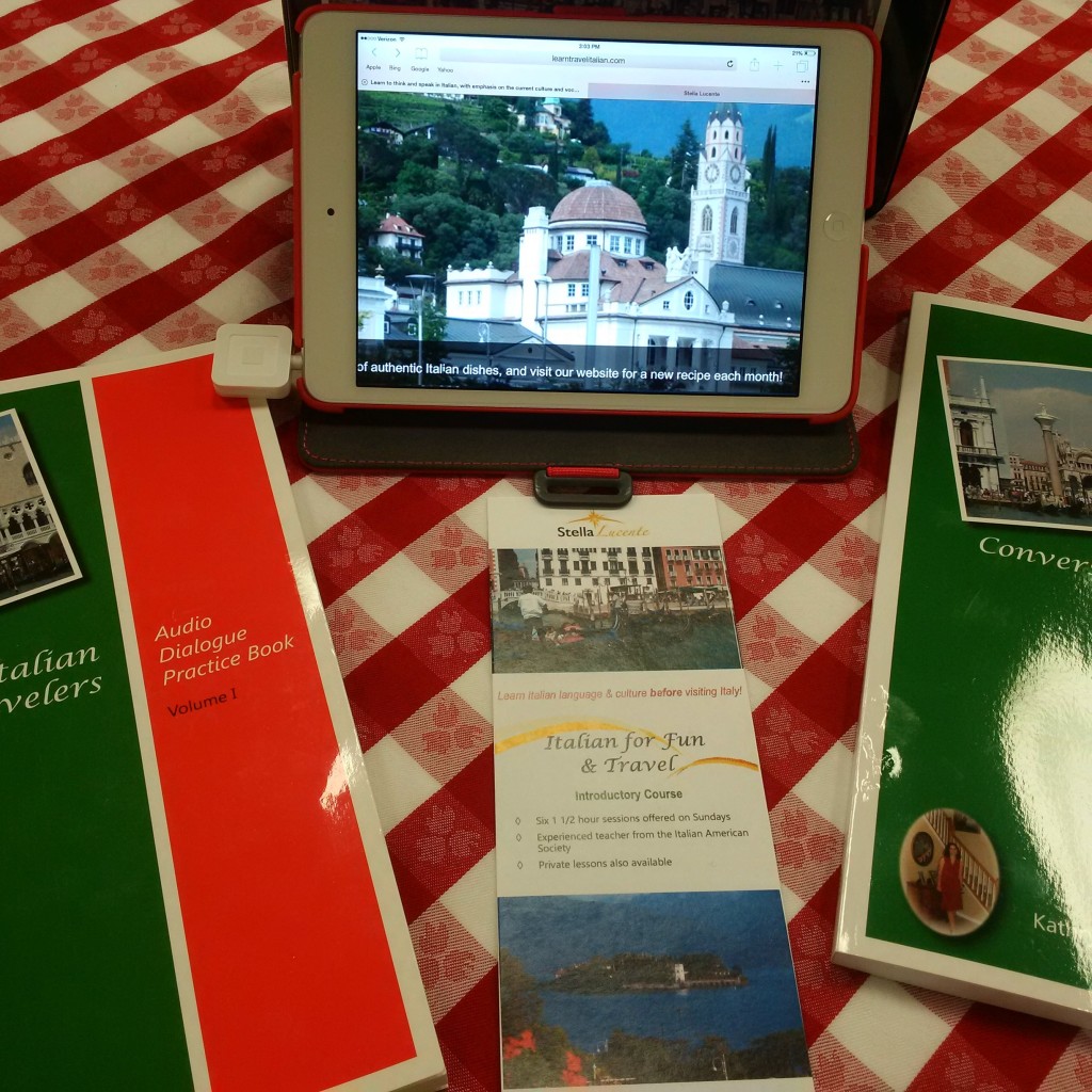 Conversational Italian for Travelers books on a red checkered table cloth with ipad set to the learntravelitalian blog.